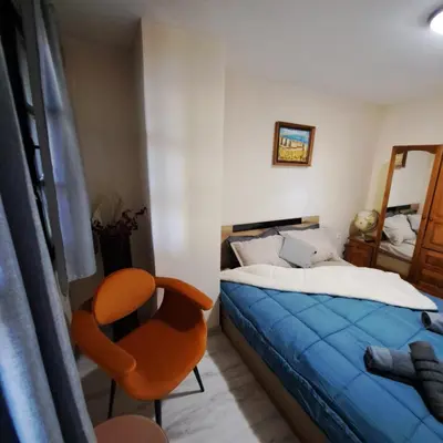 a small bedroom with a bed and a chair at Aura house in Dolna Banya