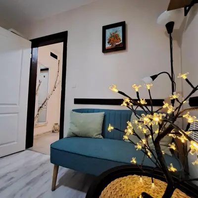 a living room with a blue couch and a tree at Aura house in Dolna Banya