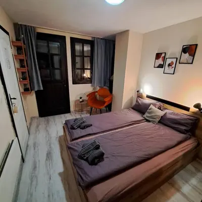 a bedroom with a large bed with purple sheets at Aura house in Dolna Banya