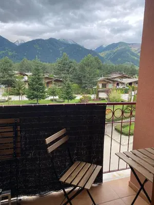 a bench on a balcony with a view of mountains at Pirin Golf private studio in Razlog