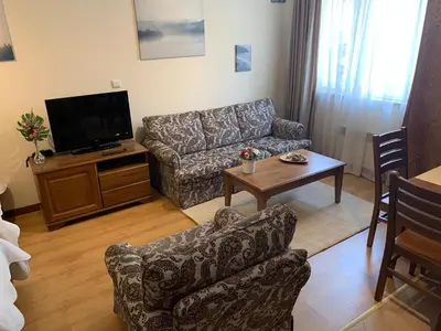 a living room with a couch and a tv at Studio 5 in Pirin Golf in Razlog