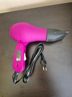 a pink hairdryer and a knife on a table at Private stay place in Sofia
