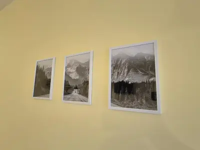 three pictures hanging on a yellow wall at Private stay place in Sofia