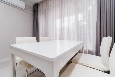 a white table and chairs in a room with a window at Cozy 2-bed Apartment in Plovdiv