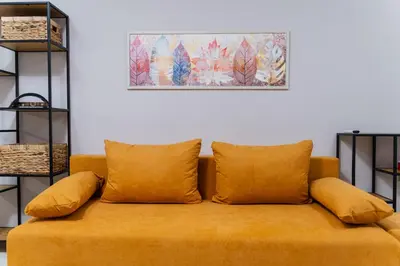 a yellow couch with pillows in a living room at Cozy 2-bed Apartment in Plovdiv