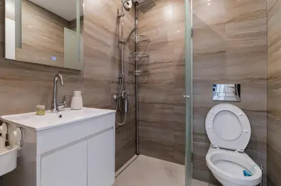 a bathroom with a shower and a toilet and a sink at Cozy 2-bed Apartment in Plovdiv