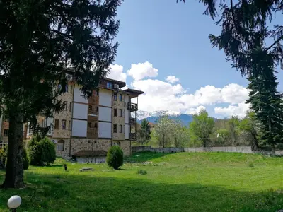 an old building in a field with a tree at Sapphire Mountain 2 in Bansko