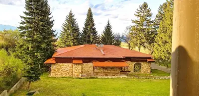 a stone house with an orange roof in a yard at Sapphire Mountain 2 in Bansko