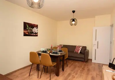a living room with a table and chairs and a couch at Momento Apartment in Kyustendil