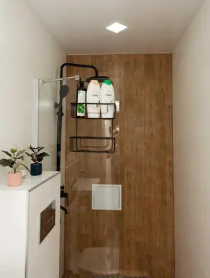a bathroom with a shower with a wooden wall at Momento Apartment in Kyustendil