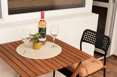 a bottle of wine and two glasses on a wooden table at Momento Apartment in Kyustendil