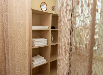 a book shelf with towels and a mirror in a bathroom at Momento Apartment in Kyustendil