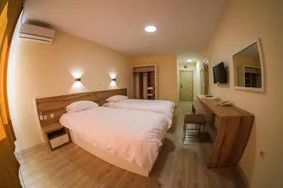 a hotel room with two beds and a desk at HOTEL BAYKO in Plovdiv