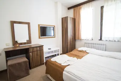 a bedroom with two beds and a vanity and a mirror at Borche Family Homes in Pamporovo