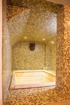 a bathroom with a tub in a room with tiles at Borche Family Homes in Pamporovo