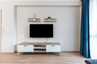 a living room with a tv on a wall at Bissera premium apartments in Sofia