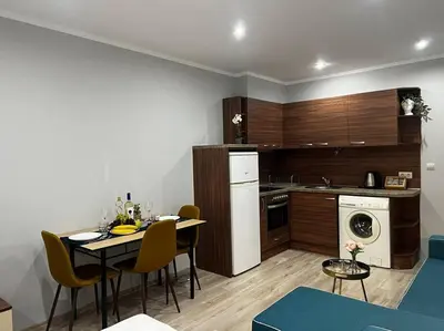 a kitchen with a table and chairs in a room at Nomadic Travelers Apartment in Sofia