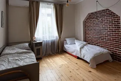 a bedroom with two beds and a brick wall at Centrally Located Vintage Flat in Sofia