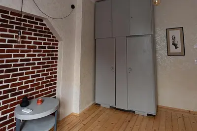 a room with a white cabinet and a brick wall at Centrally Located Vintage Flat in Sofia