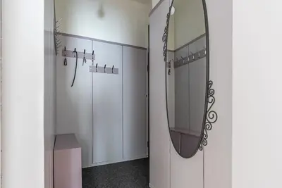 a bathroom with white cabinets and a mirror on the wall at Centrally Located Vintage Flat in Sofia