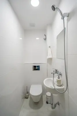 a white bathroom with a toilet and a sink at Top Location Central New & Spacious 3 BDR apt Medical Academy in Sofia