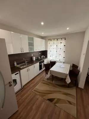 a small kitchen with a table and a sink at Къща за гости Горски рай in Smilyan