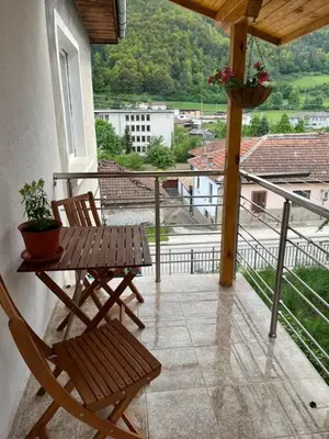 a balcony with a table and chairs and a view at Къща за гости Горски рай in Smilyan