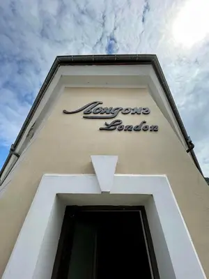 a sign on the side of a building at Лондонъ - къща за гости / London - guest house in Kyustendil
