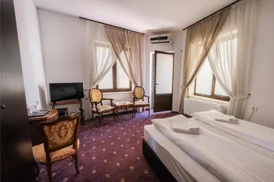 a hotel room with two beds and a television at Лондонъ - къща за гости / London - guest house in Kyustendil
