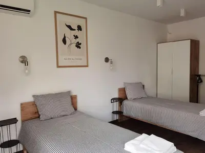a room with two beds and a picture on the wall at The Courtyard 2Bdrm Apartment in Sofia