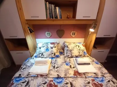 a bedroom with a bed with a floral bedspread at Аpartment Van Gogh in Hisarya