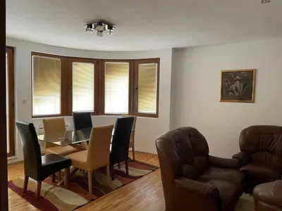 a living room with a dining room table and chairs at Vessy’s apartment in Smolyan