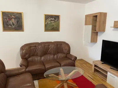 a living room with a brown leather couch and a table at Vessy’s apartment in Smolyan