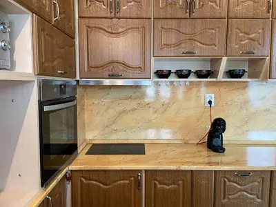 a kitchen with wooden cabinets and a counter top at Vessy’s apartment in Smolyan