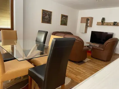 a living room with a glass table and leather chairs at Vessy’s apartment in Smolyan