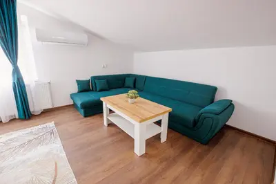 a living room with a green couch and a table at GreenBoxApartment in Kyustendil