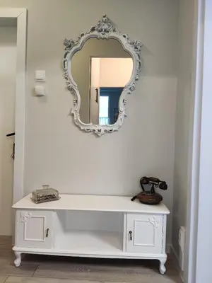 a white dressing table with a mirror on a wall at Maya's Airport Apartment in Sofia