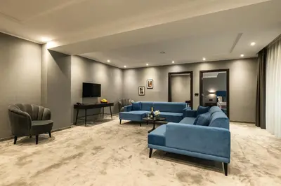 a living room with a blue couch and chairs at Empire Balneo & Spa Hotel in Hisarya