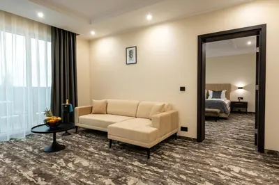 a living room with a couch and a mirror at Empire Balneo & Spa Hotel in Hisarya