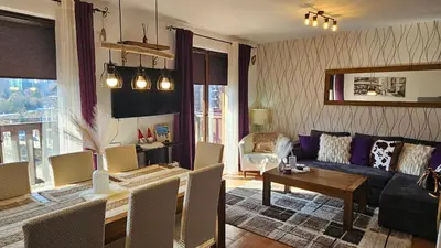 a living room with a couch and a table at Bansko Prespa Ski Penthouse in Bansko