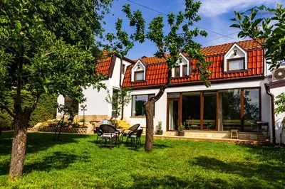 an orange roofed house with a green yard at Докторската къща in Sapareva Banya