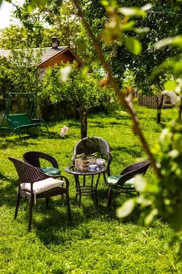three chairs and a table in the grass at Докторската къща in Sapareva Banya