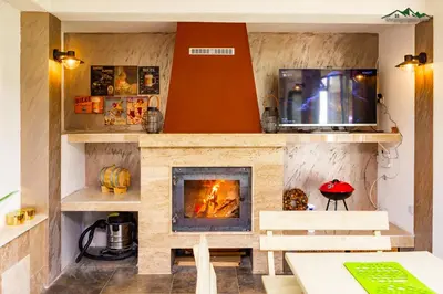 a living room with a fireplace and a tv at Докторската къща in Sapareva Banya
