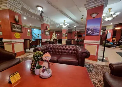 a waiting room with a leather couch and a table at Grand Monastery Pamporovo Luxury Apartment in Pamporovo