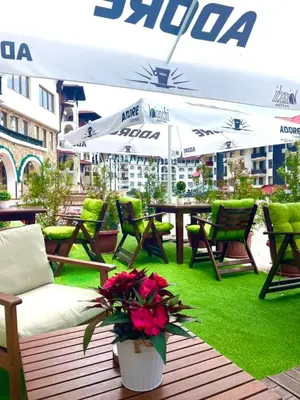 a patio with chairs and a table with flowers at Grand Monastery Pamporovo Luxury Apartment in Pamporovo