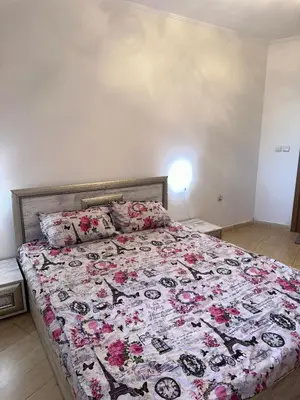 a bedroom with a large bed with pink flowers on it at Grand Monastery Pamporovo Luxury Apartment in Pamporovo