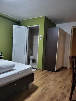 a bedroom with a bed and a bathroom with a toilet at Solar in Plovdiv