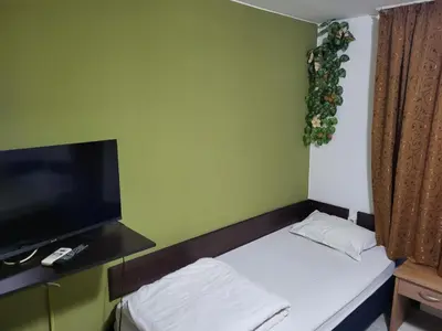 a small room with a bed and a flat screen tv at Solar in Plovdiv