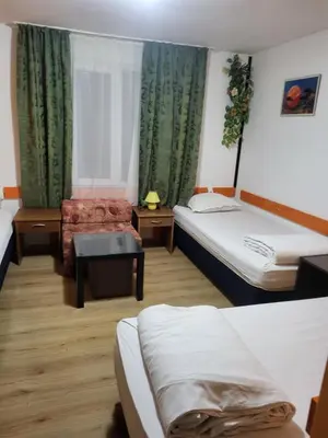 a hotel room with two beds and a chair at Solar in Plovdiv