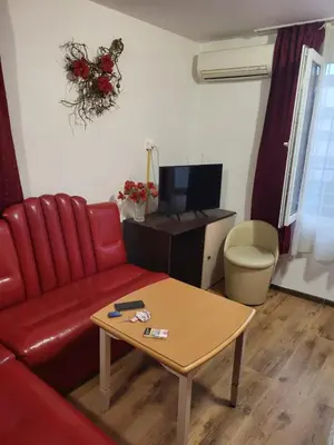 a living room with a red couch and a table at Solar in Plovdiv